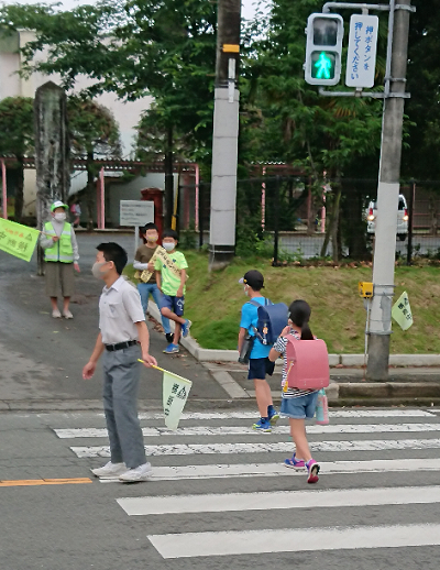 横断歩道を渡る小学生をサポートする中学生