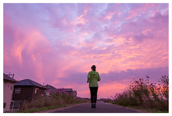 夕暮れの道のジョギング風景